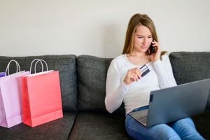 Una mujer comprando en línea en un sofá usando Chatfuel, un agente de ventas de IA.